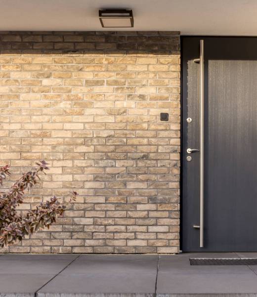 Minimalist clean red brick home exterior with black front door